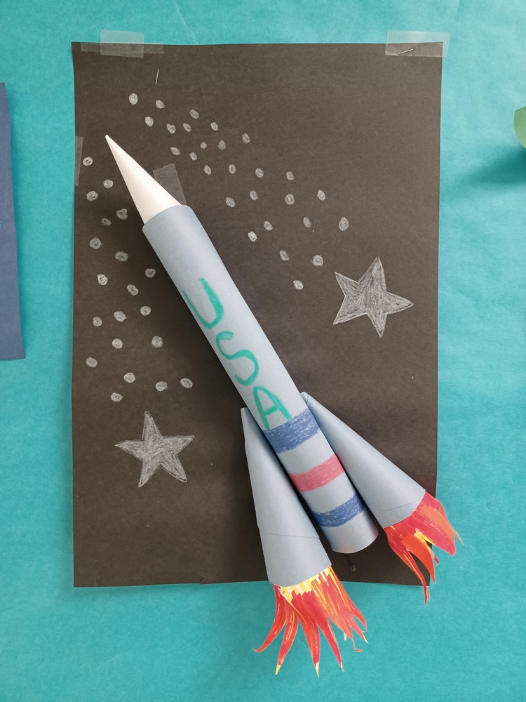 Art depicting a rocket traveling through space.