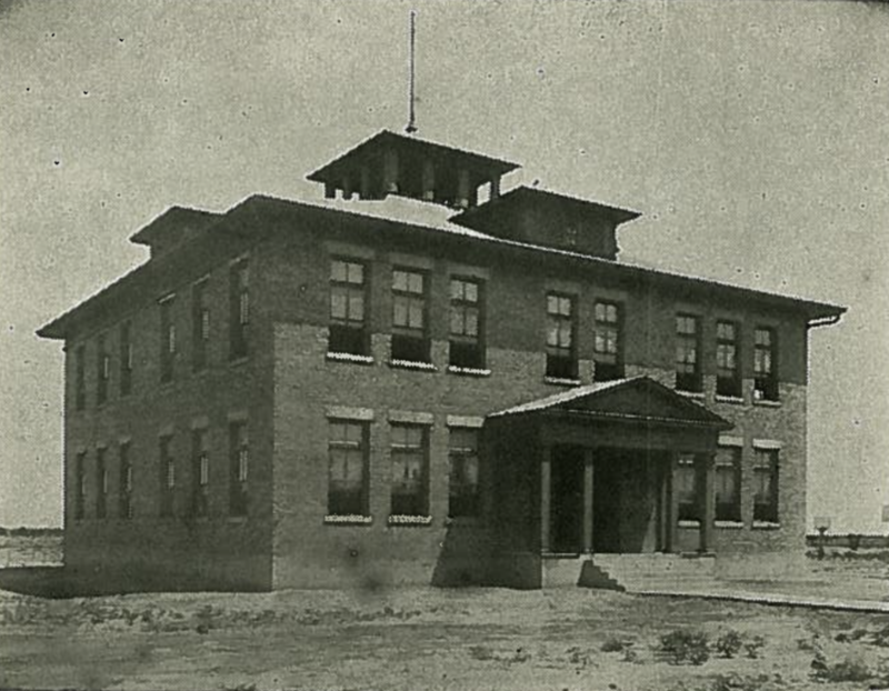 Grainy, black and white photo of elementary school building circa 1910